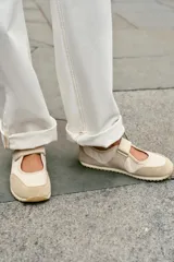 Bailarina deportiva tipo barefoot en color beige, con puntera amplia, cierre de velcro en el empeine, detalles en gamuza y suela flexible de goma.