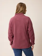 Buzo de polar con cuello alto y medio cierre frontal. Presenta un diseño de manga larga con puños elásticos y logo bordado en el pecho.