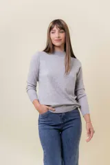 Buzo de tejido fino color amarillo claro, con cuello semi alto, manga larga y calce regular.