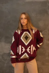 Sweater de punto color bordó con diseño geométrico tejido en tonos blancos, beige y marrones, de corte holgado y mangas largas.