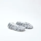Pantuflas de tela suave con diseño de estampado animal print en tonos grises y blancos, forradas en su interior con material afelpado.