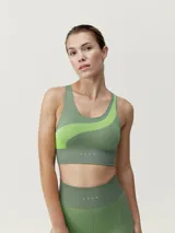 Top deportivo verde con diseño bicolor, de sujeción media alta, tejido seamless con tecnología 3D y patrón acanalado.