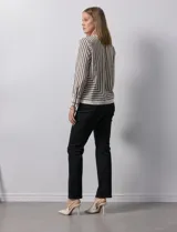 Blusa de gasa estampada con líneas verticales negras sobre fondo beige, de manga larga con puño abotonado. Espalda con abertura y botón.