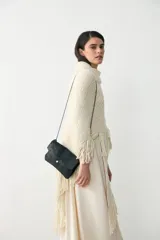 Bandolera pequeña de cuero negro con acabado laminado, diseño tipo sobre con cierre de broche a presión y correa de cuero fina extraíble.