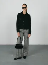 Campera verde militar de pana con cuello camisero, cierre frontal con botones a tono, dos bolsillos de parche con solapa en el pecho y corte cropped.