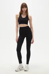 Calza deportiva de tiro alto y ajuste al cuerpo, confeccionada en tejido elástico de color negro.