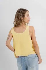 Chaleco celeste de punto con escote en V y cierre frontal con botones. Tejido calado y corte holgado.