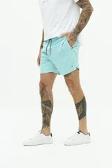 Short de baño liso con cintura elástica y cordón ajustable. Cuenta con dos bolsillos laterales, un bolsillo trasero y logo bordado en el ruedo. Confeccionado en tejido ligero de secado rápido.