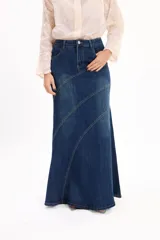 Pollera larga de denim con tiro alto, diseño ajustado en la parte superior y corte acampanado hacia el ruedo. Presenta costuras decorativas en diagonal que aportan movimiento y estructura a la prenda.