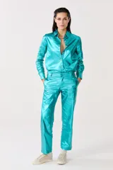 Pantalón de lino metalizado color turquesa, de corte clásico, tiro medio, piernas rectas y bolsillos laterales.