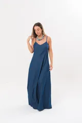 Vestido largo de denim fino y liviano, color azul, con breteles finos, escote en V y falda amplia con recortes verticales y bolsillos laterales.