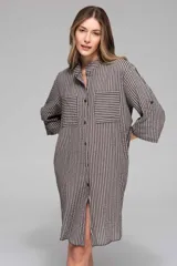 Vestido camisero oversize a rayas verticales en tonos gris y negro, con cuello mao, botonadura frontal, bolsillos frontales a la altura del pecho y mangas 3/4 con opción de arrollar.