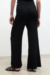 Pantalón largo color crema, de punto acanalado y corte recto.