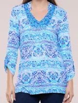 Remera de rayón con estampado paisley y geométrico en tonos de azul y celeste, con escote en V pronunciado y mangas 3/4 con sistema roll-up.