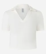 Blusa de cuello polo y manga corta, confeccionada en tejido rib de algodón con elastano. Presenta un diseño ajustado al cuerpo con escote en V y textura acanalada.