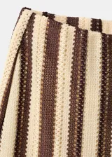 Pantalón de tiro medio con cintura elástica y corte recto, confeccionado en tejido de punto con diseño de rayas verticales en tonos marrón y beige.