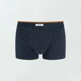 Pack de tres boxers de algodón elástico, uno liso color ocre, uno a rayas horizontales azul y ocre, y uno azul con estampado de hojas color ocre.