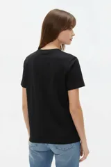 Remera de manga corta de algodón en color blanco, con cuello redondo y diseño holgado. Cuenta con un estampado frontal central con detalles metalizados estilo foil.