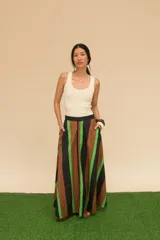 Pollera larga de cintura alta con rayas verticales marrones, negras y verdes. Confeccionada en algodón, con bolsillos laterales y corte evasé.