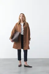 Top negro de manga corta con detalle de nudo en el escote y abertura tipo gota. Presenta una silueta relajada y textura sutil en la tela.