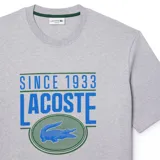 Camiseta gris de manga corta con estampado frontal del logo de Lacoste y la leyenda "Since 1933".