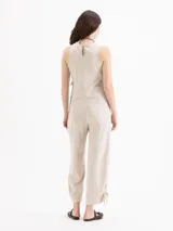 Pantalon de tiro medio color beige, confeccionado en twill, con fit relajado, pierna ancha estilo babucha, bolsillos laterales y traseros tipo ojal, y presillas en la cintura.
