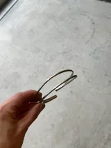 Brazalete rígido abierto de metal plateado con doble aro.