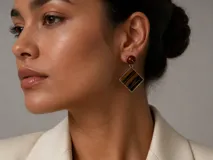 Aros colgantes artesanales con diseño geométrico romboidal, realizados mediante la técnica de taracea con láminas de madera en tonos naturales y negros, rematados con una esfera de coral rojo y engarce en plata.