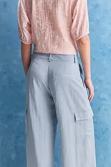 Pantalón cargo celeste de tiro alto y pierna amplia, con bolsillos laterales y bolsillos cargo con tapa.
