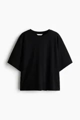 Remera de punto suave de algodón, color negro, con cuello redondo ribeteado y diseño de mangas murciélago cortas con volumen.