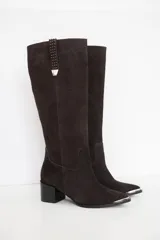 Bota bucanera de cuero color marrón oscuro, con taco cuadrado de 6 cm y punta fina con detalle metálico. Presenta una tira vertical decorativa con tachas metálicas en la parte superior de la caña.