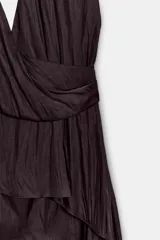 Top de escote en pico cruzado con tirantes finos ajustables y bajo asimétrico con caída fluida.