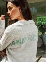 Camisa de lino con diseño de cuadrillé en tonos blanco y beige, de manga larga y cuello clásico. Presenta una pequeña estampa en el pecho y una estampa en la espalda, con un calce holgado y relajado.