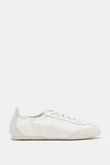 Zapatilla deportiva color blanco con detalles en gamuza y diseño de talonera elástica, cordones al tono y suela plana dentada.