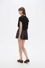 Short cargo negro de poliéster, con cintura elástica fruncida y cordón ajustable. Posee bolsillos laterales tipo cargo.
