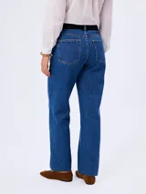 Pantalón de jean de corte recto, con tiro medio y lavado azul medio. Cuenta con cinco bolsillos clásicos, cierre de botón y bragueta, y terminación recta con ruedo desflecado.