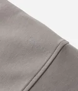 Buzo de cuello alto con cierre frontal parcial, manga larga y puños ajustados. Presenta un diseño minimalista en color verde militar.