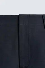 Pantalón de corte balloon fit, color negro, con bolsillos laterales de vivo y bolsillos traseros con solapa. Presenta cierre frontal con cremallera y botón.