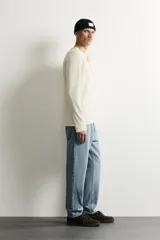Jeans de corte slim cropped confeccionados en denim de algodón rígido con efecto lavado. Presentan tiro medio, cierre frontal con cremallera y botón, y diseño clásico de cinco bolsillos.