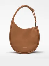 Bolso hobo color marrón claro, con textura napa y asa tubular con pieza metálica. Tiene un compartimento con cierre de clip magnético y un bolsillo interior con cremallera.