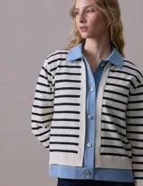 Campera combinada marca Nanette, con torso y mangas en tejido a rayas horizontales blancas y negras. Solapa, puños y cierre en denim celeste. Cierre frontal con botones metalizados.