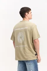 Remera oversize de color azul marino, de manga corta y cuello redondo. Presenta un diseño estampado en la espalda con la inscripción "Boundless Art", un gráfico circular abstracto y textos adicionales.