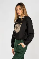 Sweater negro de algodón con cuello y puños de encaje, y estampado frontal con la palabra "Vintage" sobre un fondo de texto antiguo.