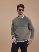 Sweater de punto verde militar con cuello redondo, mangas raglán y un pequeño bolsillo en el pecho con detalle de parche con logo.