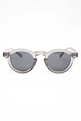 Lentes de sol polarizados con armazón redondo de acetato en tono gris traslúcido y cristales oscuros.