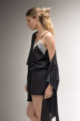 Pijama de algodón negro, compuesto por una musculosa con escote en V y puntilla blanca elastizada, y un short con elástico y lazo en la cintura.