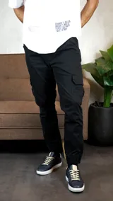 Pantalón tipo cargo con diseño jogger en color negro, con bolsillos laterales tipo cargo y puños elásticos en los tobillos.