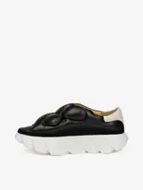 Zapatillas negras de cuero con plataforma blanca y talonera blanca en contraste. Presentan cuatro correas de velcro y suela con dientes de gran formato.