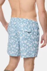 Short de baño celeste con estampado floral blanco, cintura con elástico y cordón regulable, bolsillos laterales y suspensor de malla fina.