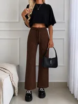 Pantalón de lanilla color beige con sutiles destellos brillantes, de corte recto y holgado. Cuenta con cintura elástica con cordón ajustable.